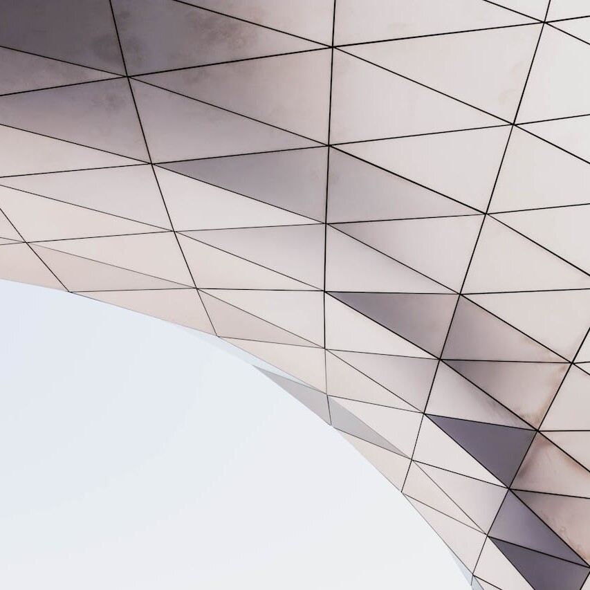 Modern architectural structure with triangular glass panels forming a curved geometric surface