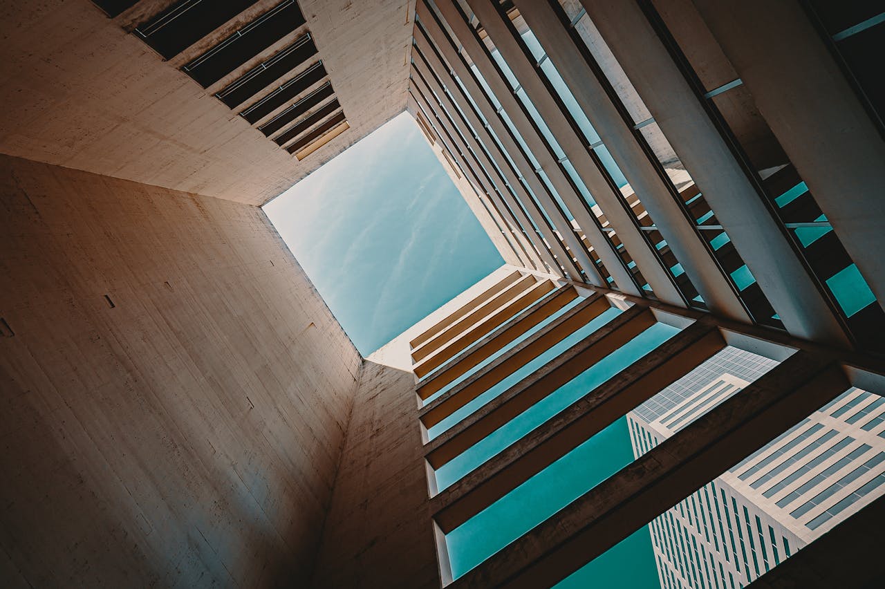 Modern skyscraper courtyard view looking up to the sky with geometric lines