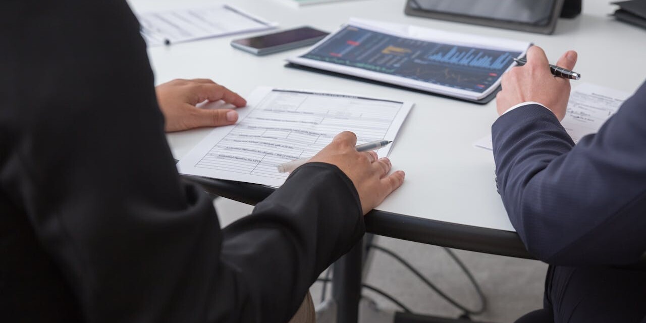 Business professionals analyzing financial data and taking notes during a strategy meeting