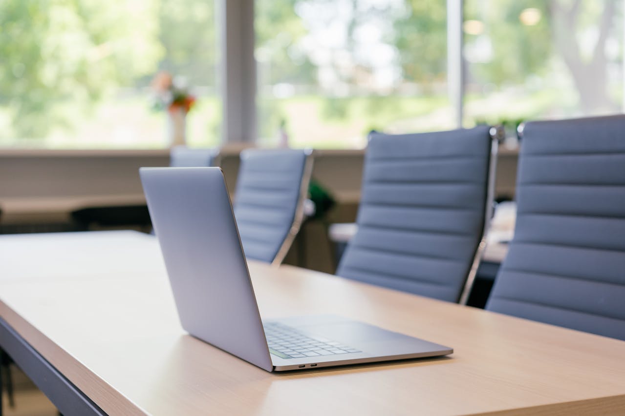 Modern laptop on a boardroom table in a bright office meeting room