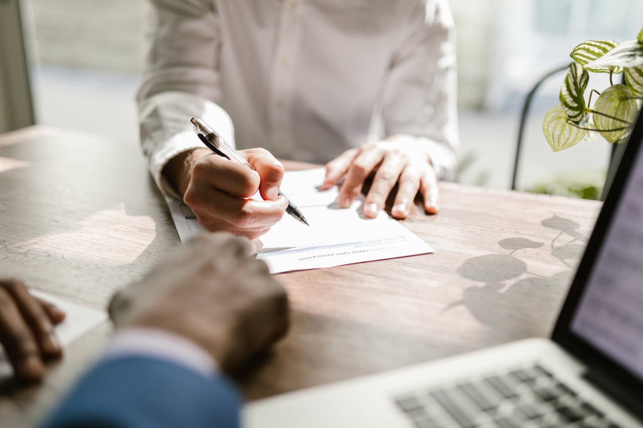 Business professional signing a document during a formal meeting at the office