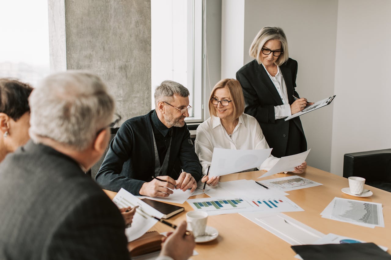 Senior professionals in a business meeting reviewing financial reports and charts
