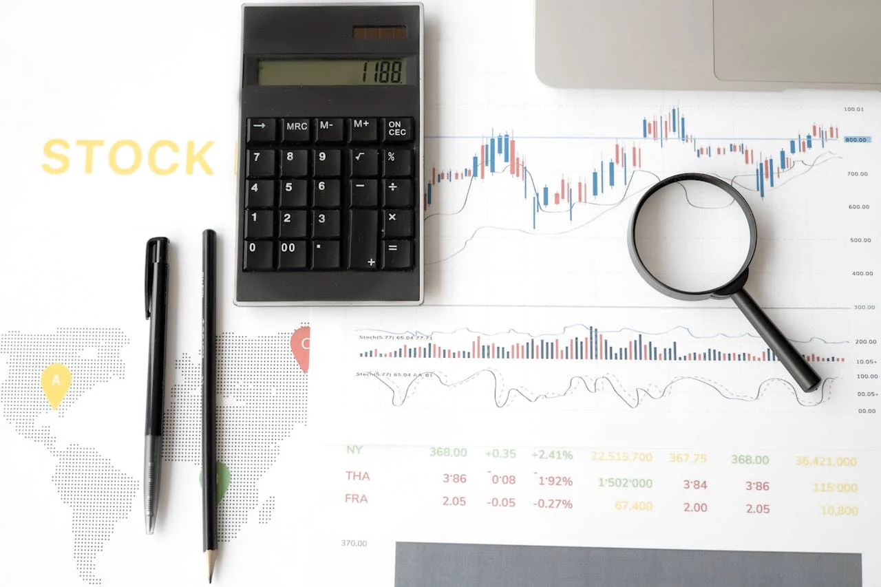 Financial analysis tools on stock market chart including calculator, magnifying glass, and technical indicators